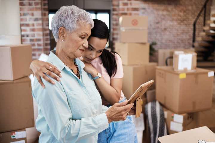 A loving daughter supports her mom while downsizing, sharing memories together as they prepare for her move to a senior living community.