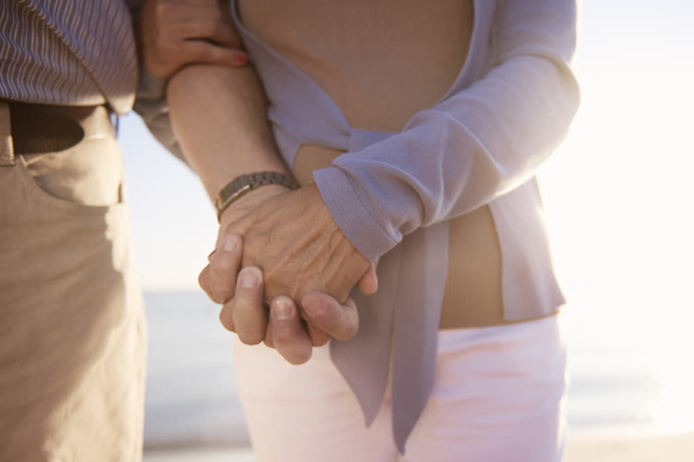 Seniors holding hands on the beach at MuirWoods Memory Care in Petaluma, California