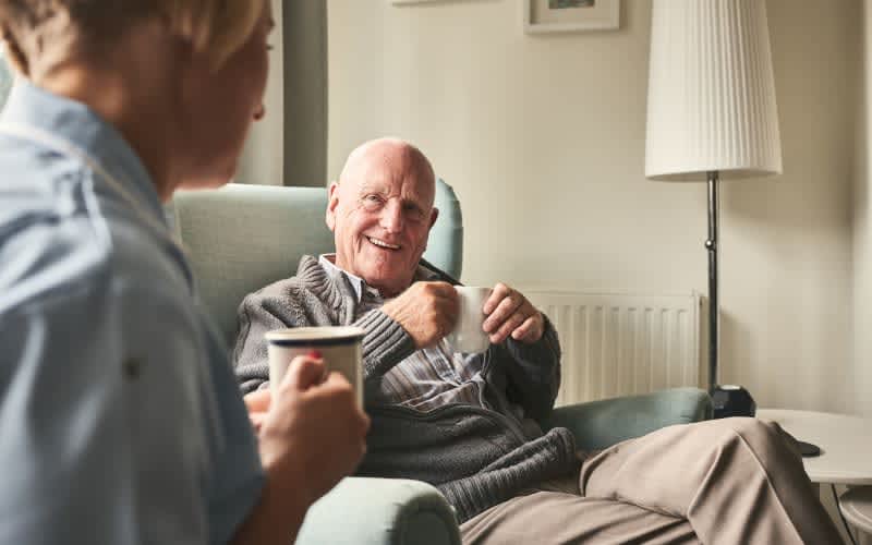 Resident having coffee with a caregiver at Silver Creek in St. Augustine, Florida