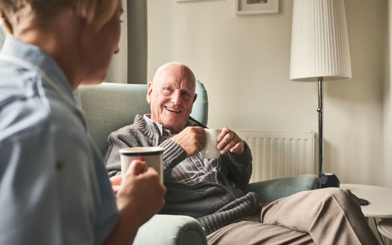 Resident having coffee with a caregiver at Elan Manatee in Bradenton, Florida