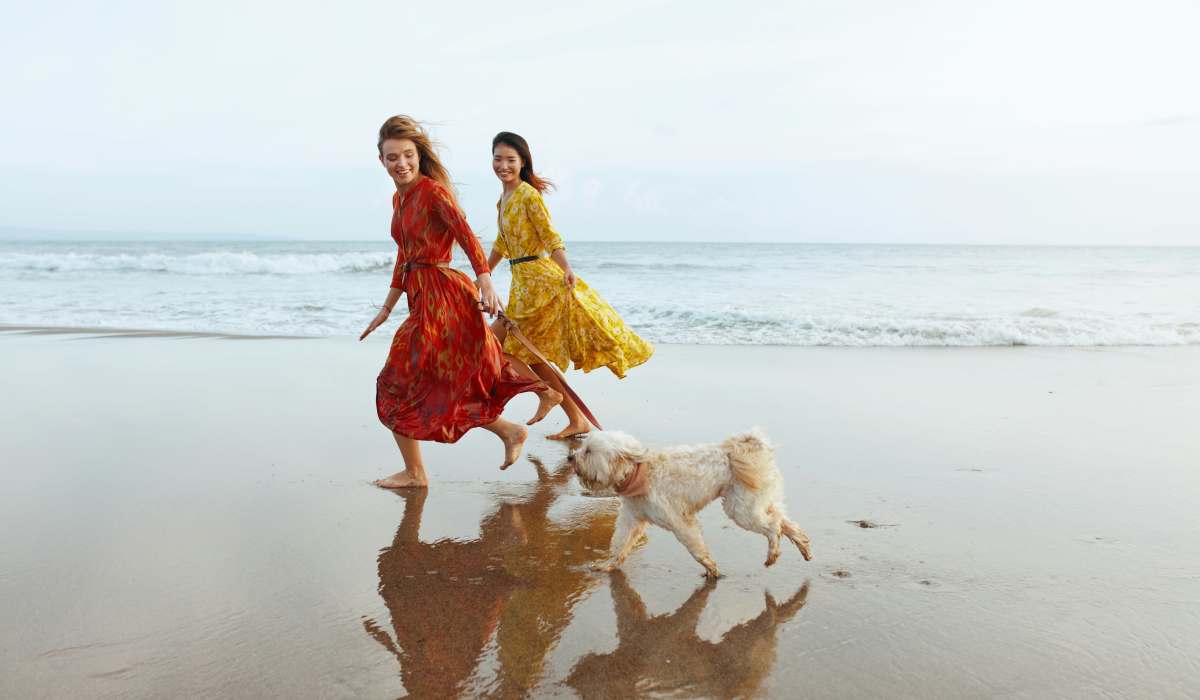 Residents running with their dog on the beach near The George Apartment Homes in Anaheim, California