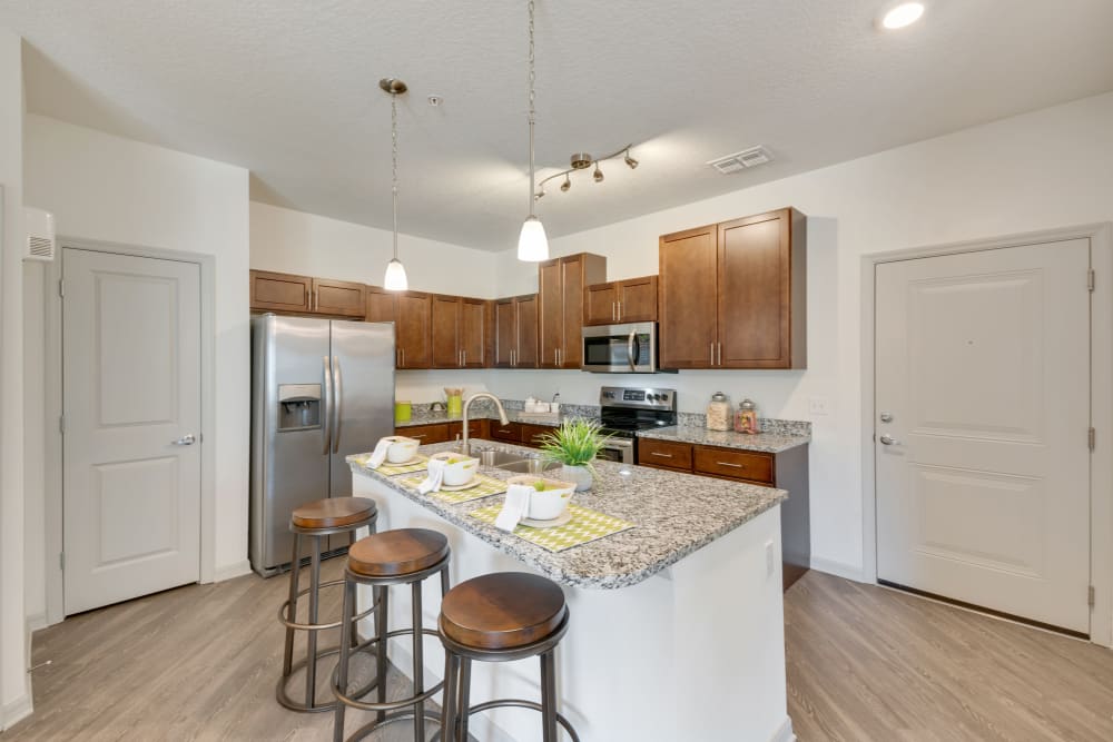 Gorgeous kitchen with pendant lights and island at Champions Vue Apartments in Davenport, Florida