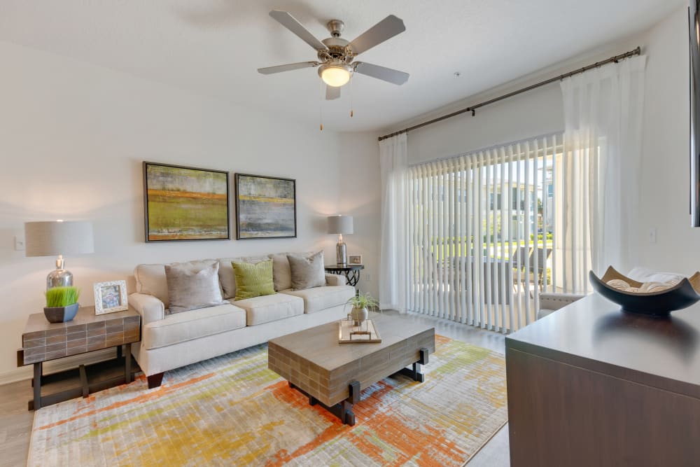 Model living room with private balcony access at Champions Vue Apartments in Davenport, Florida