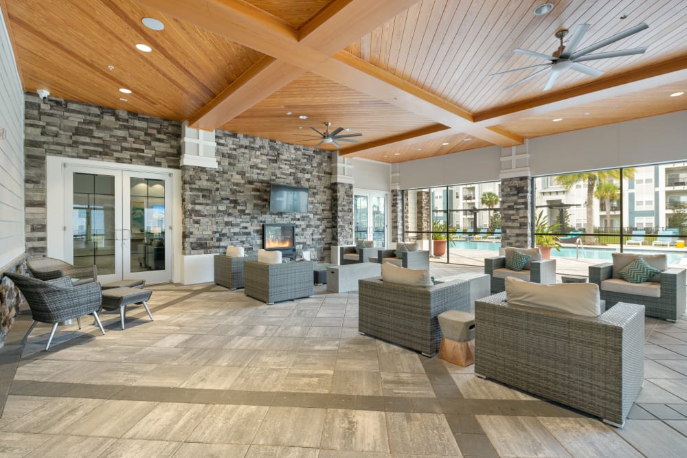Clubhouse lounge seating and outdoor fireplace at Champions Vue Apartments in Davenport, Florida