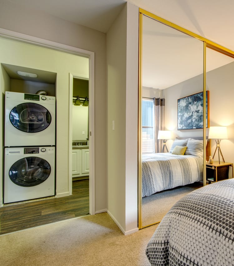 View of the in-unit washer and dryer from a model home's bedroom at Terra Martinez in Martinez, California