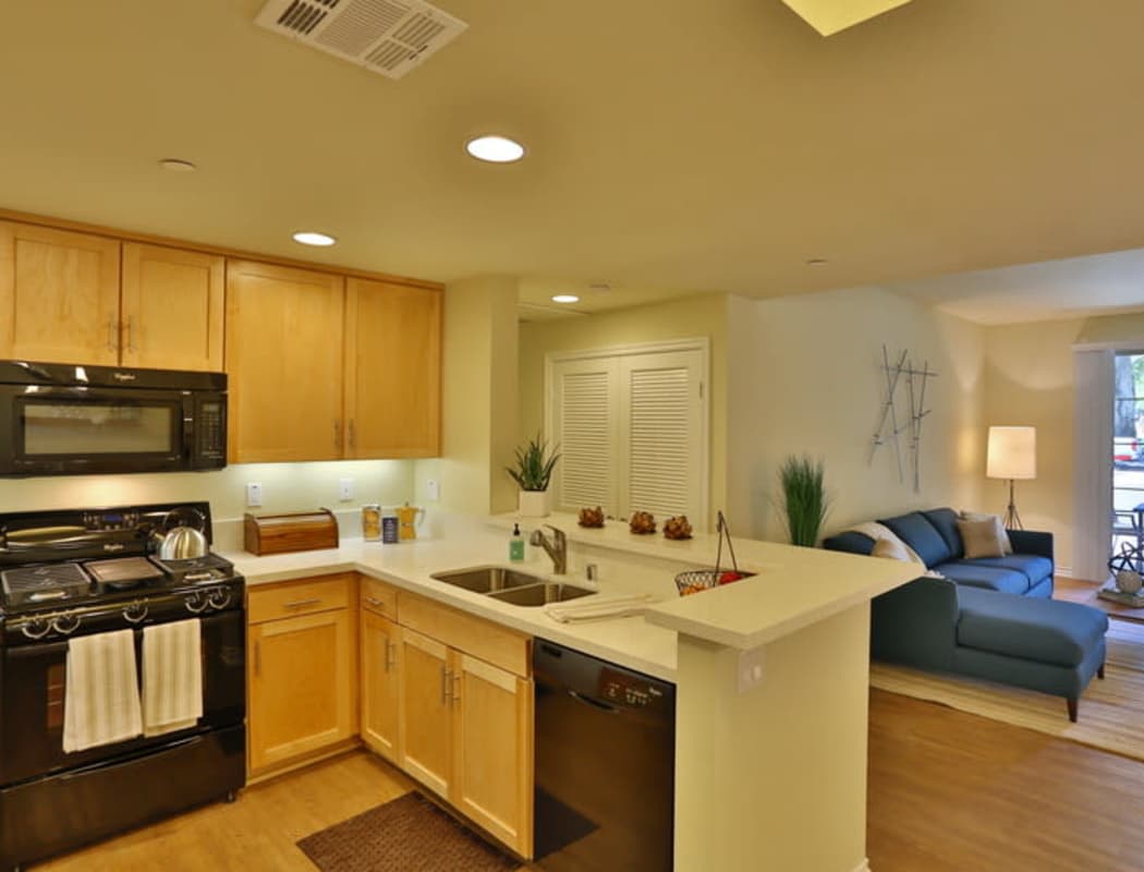 Model apartment kitchen looking into living area at IMT Park Encino in Encino, California