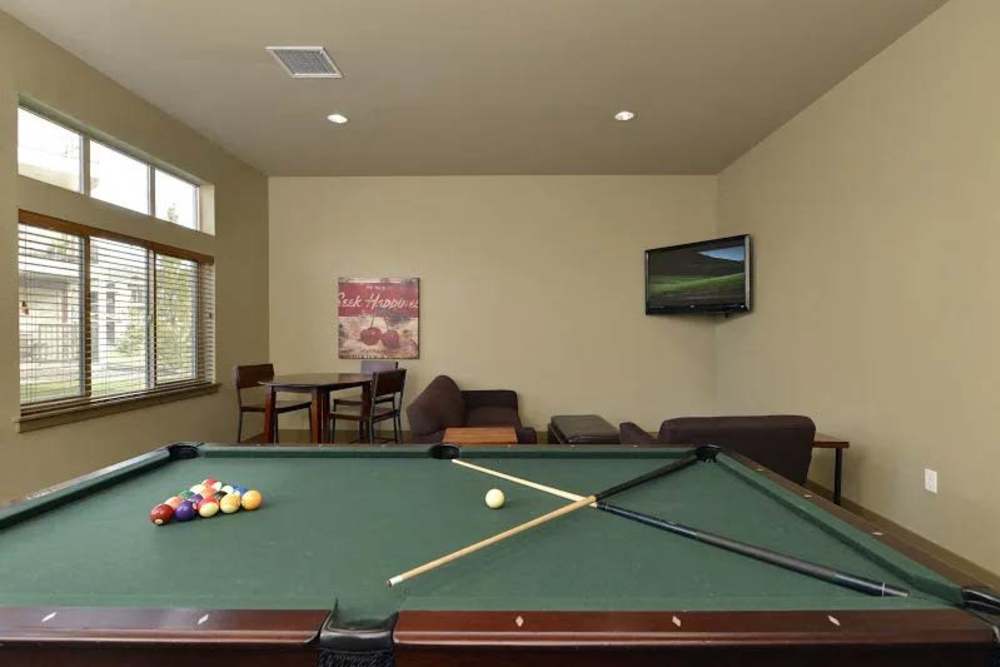 Fully-equipped game room with pool and flat-screen TVs at Copper Wood in Lacey, Washington