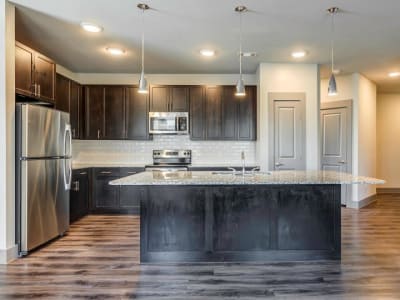 Gourmet kitchen with granite countertops and island at Discovery Park in Denton, Texas