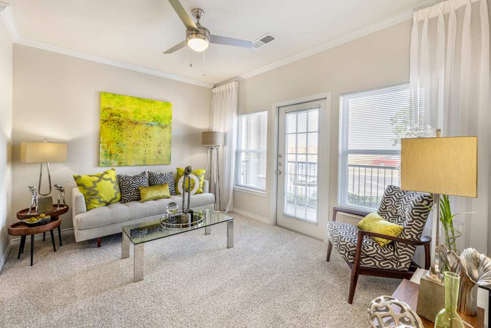 Spacious living room with access to patio through glass door at New Longview in Lee's Summit, Missouri
