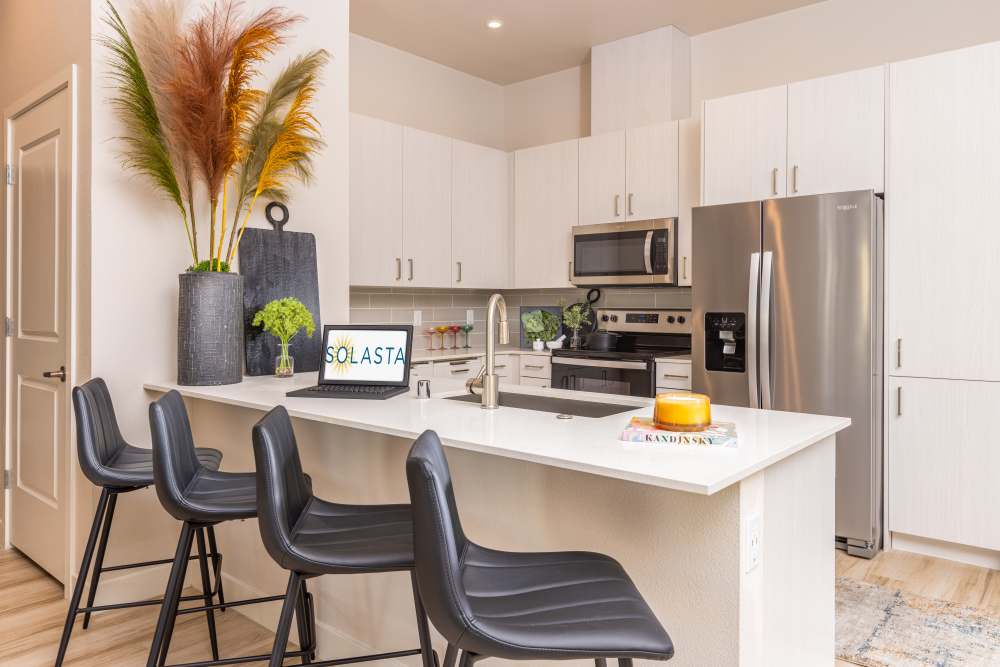 Kitchen with island and counter stools at Solasta in Sacramento, California