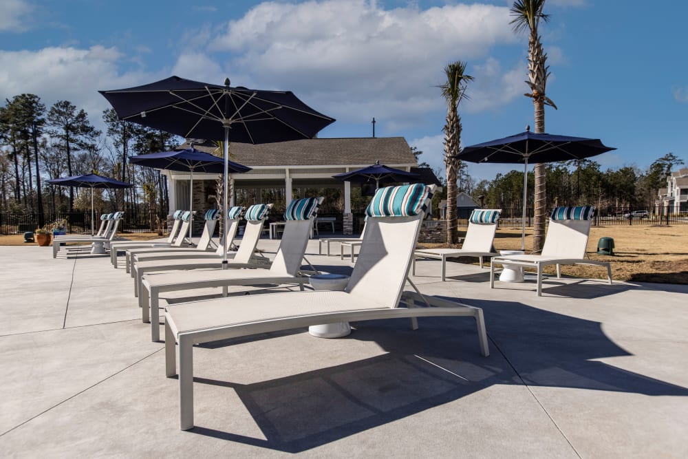 Pool lounge chairs at South City Apartments in Summerville, South Carolina