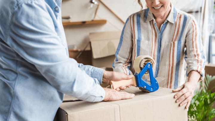 Couple taping a packing box