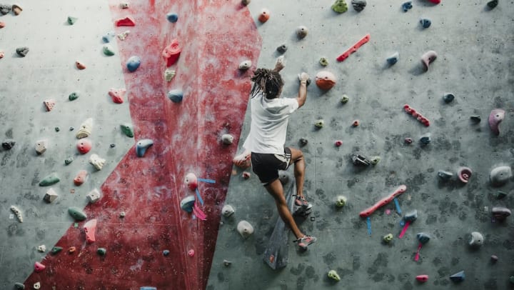 A lone climber on an indoor climbing wall