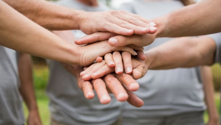 Volunteers clasping hands at Legends at White Oak in Ooltewah, Tennessee