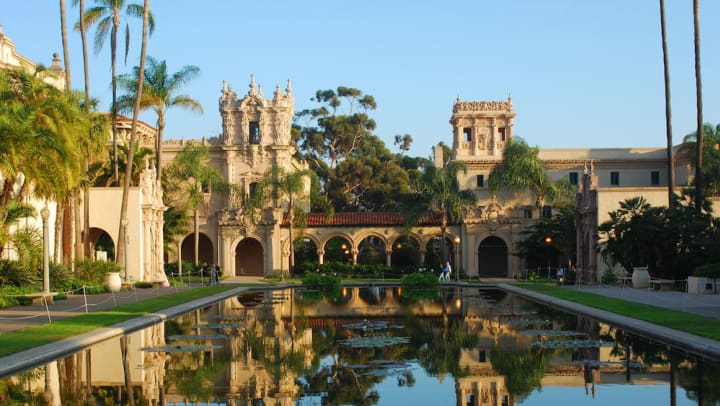 A building with beautiful architecture in front of a pond in Balboa Park