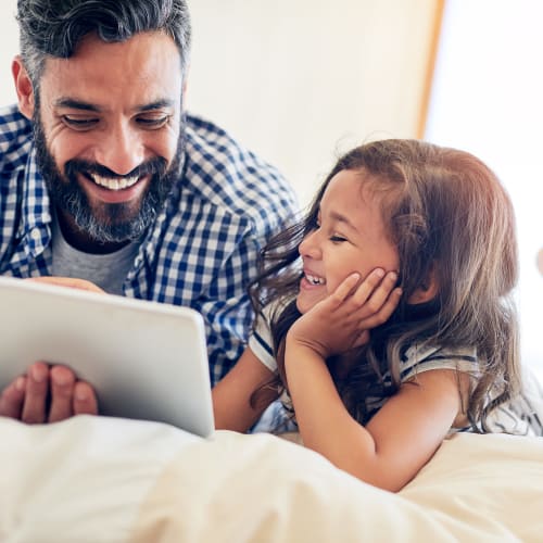 A father reading a story for his daughter on the bed at Joshua Heights in Twentynine Palms, California