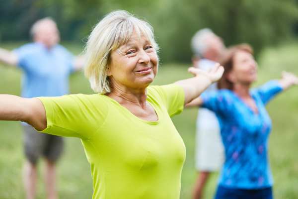 Senior practicing yoga in a peaceful, well-lit community fitness space, focused and relaxed.