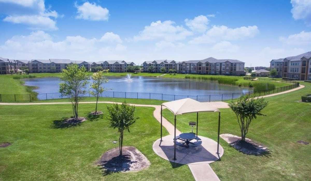 Beautiful view of lake, surrounding green grass and trees right outside apartments at
