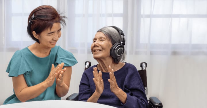 a senior lady listening music with her caregiver