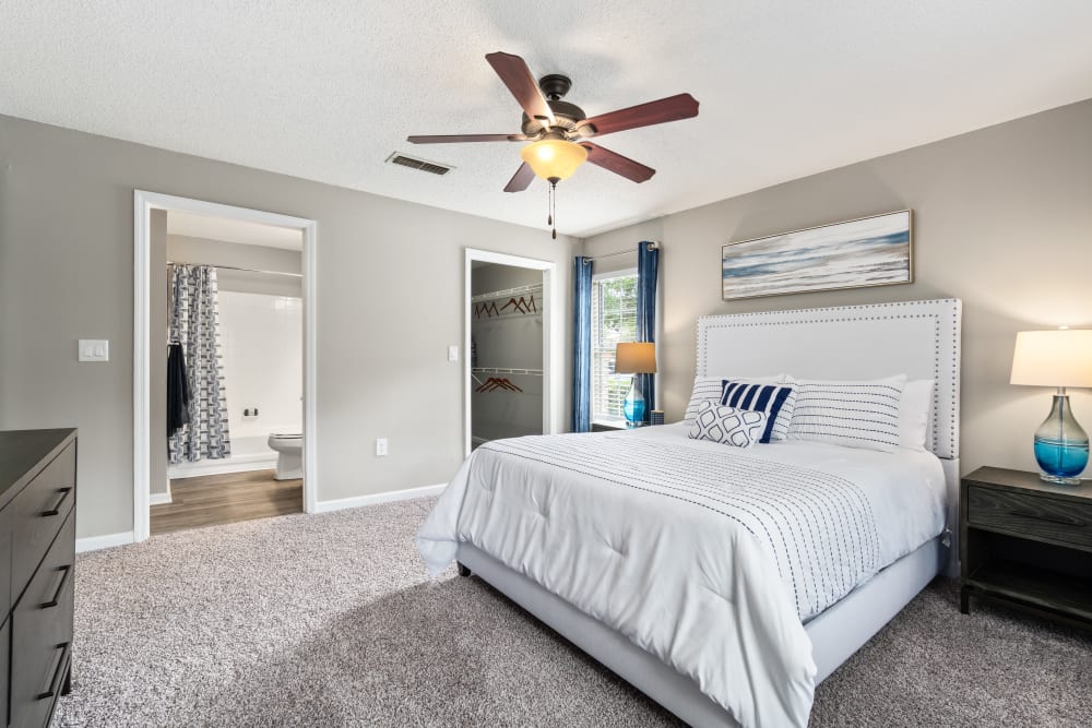 An apartment bedroom with a sliding glass door to the balcony at Gates at Jubilee in Daphne, Alabama