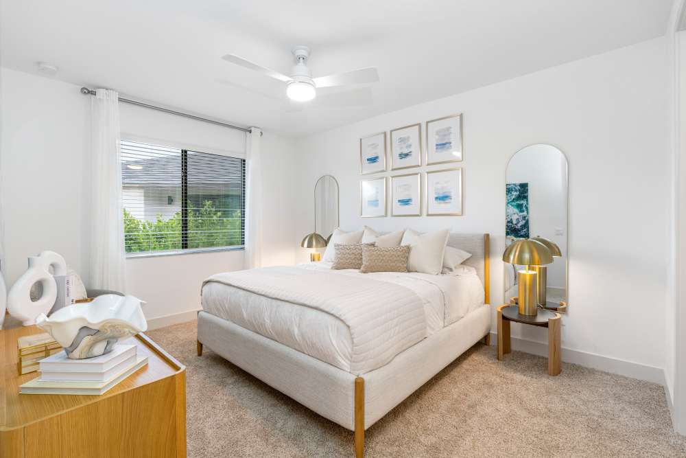 Bed with decorative pillows and artwork above at Solera at Avalon Trails in Delray Beach, Florida