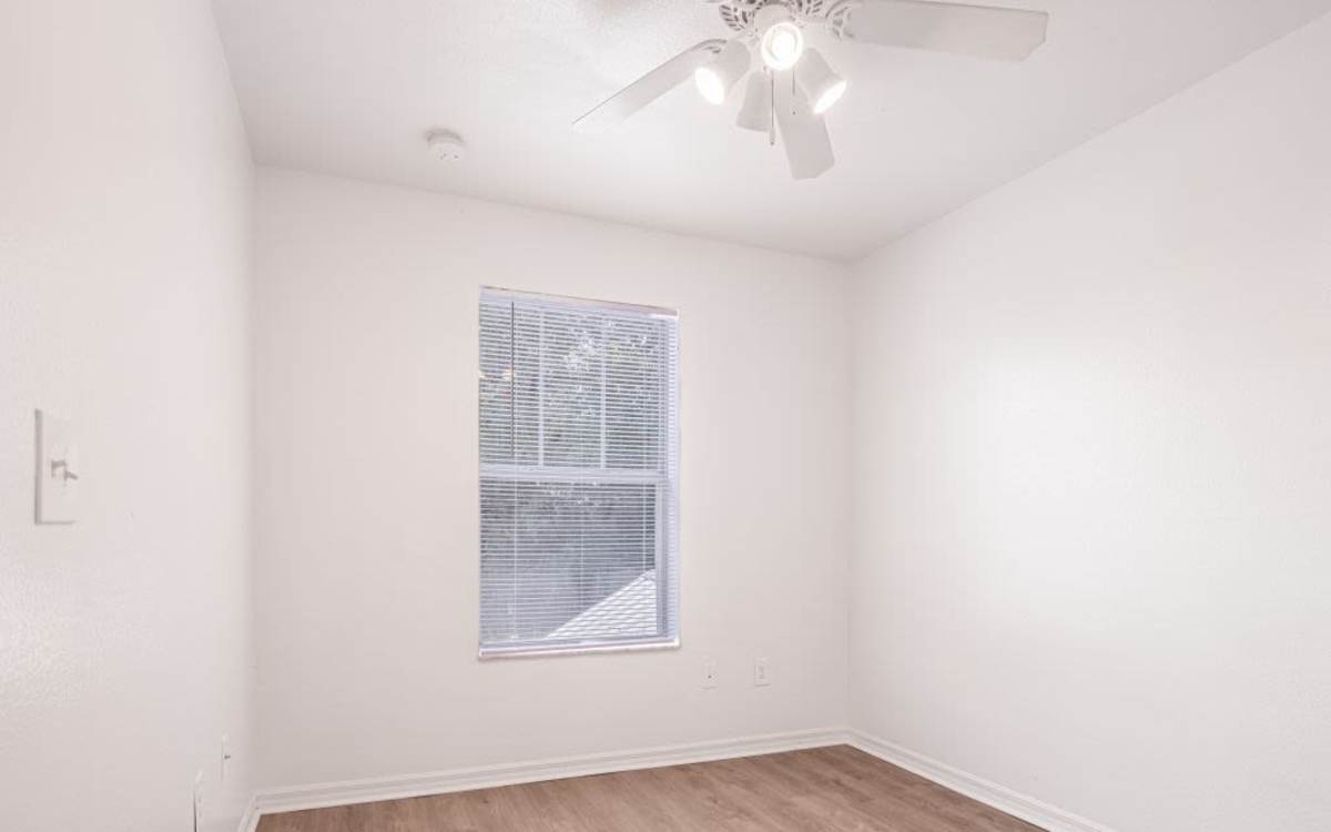 Bedroom with a large window and a ceiling fan at Cypress Commons in Wildwood, Florida