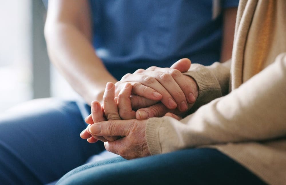 Caretaker holding the hands of a resident at Amira in Bloomington, Minnesota