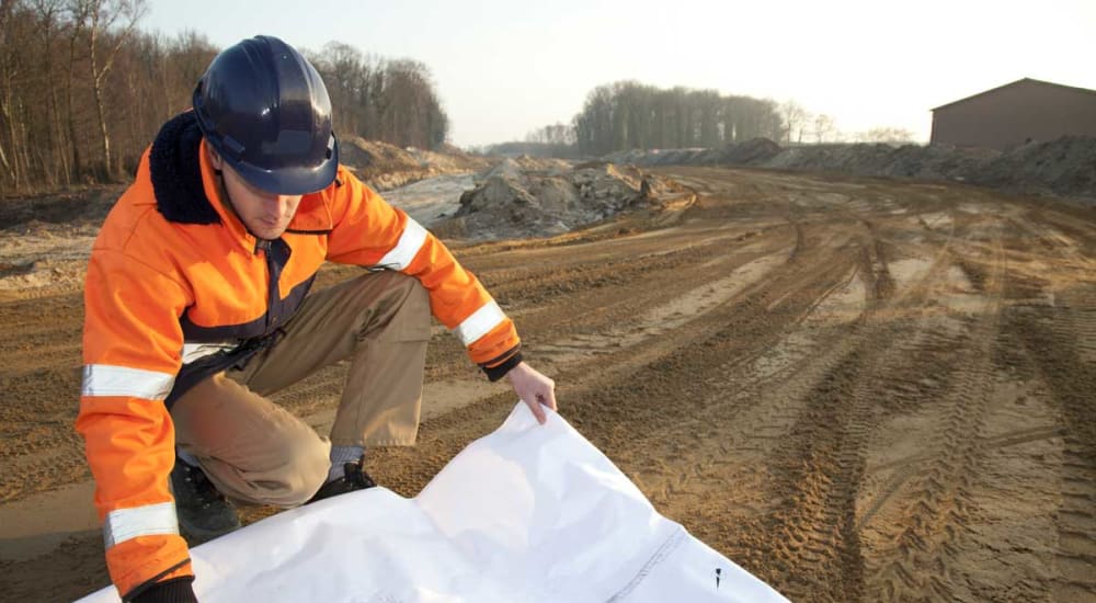 Construction worker reading blue prints at a American Capital Group job site in Bellevue, Washington