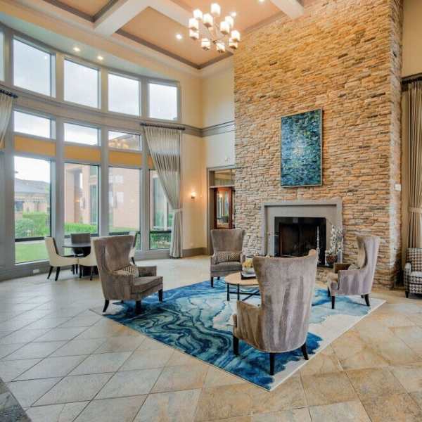 Community clubhouse with chairs and fireplace at Grand Fountain in Richmond, Texas