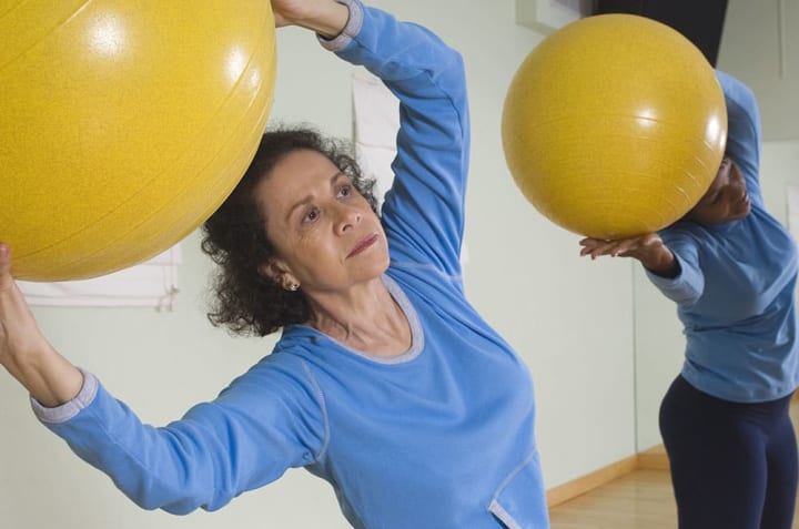 Residents exercising with therapy balls. 