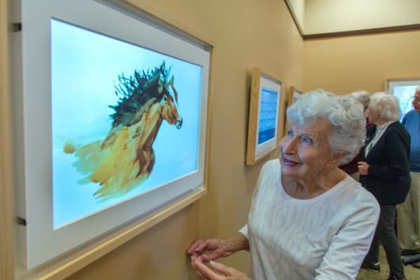 A resident look at a photo at a gallery near Courtyards at Berne Village in New Bern North Carolina