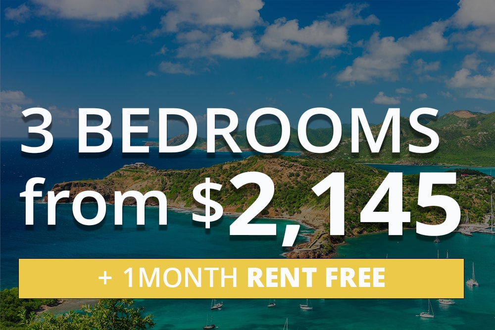 Aerial view of a tropical island with turquoise water, green hills, and sailboats. Overlaid text reads: '3 Bedrooms from $2,145' and '+ 1 Month Rent Free' in a yellow banner.