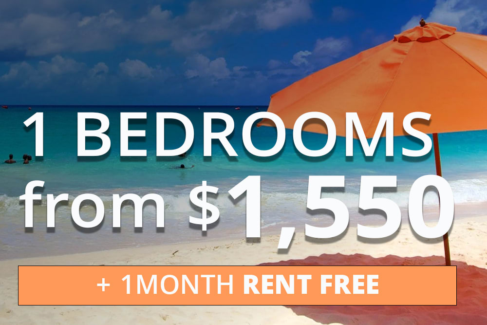 Beach scene with turquoise water, white sand, and an orange umbrella. Overlaid text reads: '1 Bedrooms from $1,550' and '+ 1 Month Rent Free' in an orange banner.