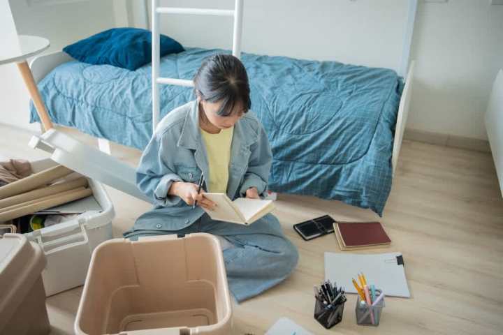 Young woman organizing her college dorm room