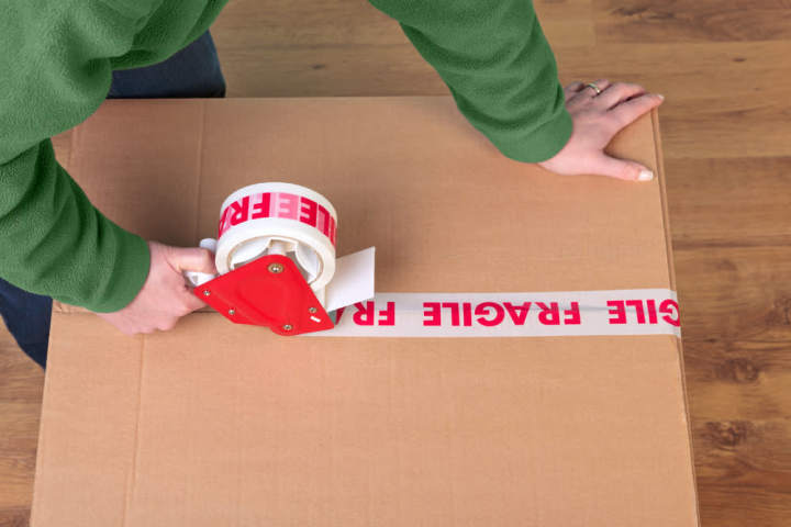 Woman labeling her moving box as fragile