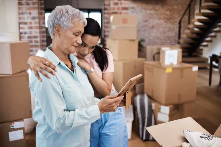 Mother is comforted by daughter while packing to downsize into a retirement home