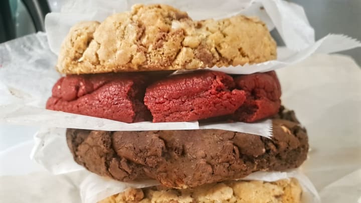 A stack of baked cookies with parchment paper in between each cookie