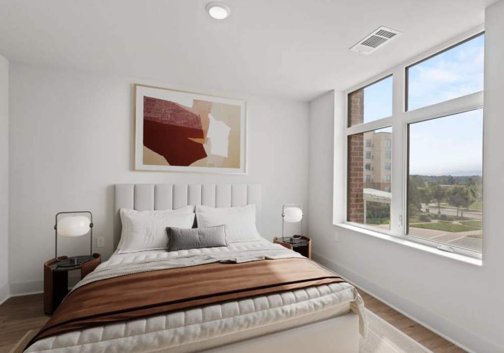 Model bedroom with wood-style flooring at The Maximillian at Stonefield in Charlottesville, Virginia