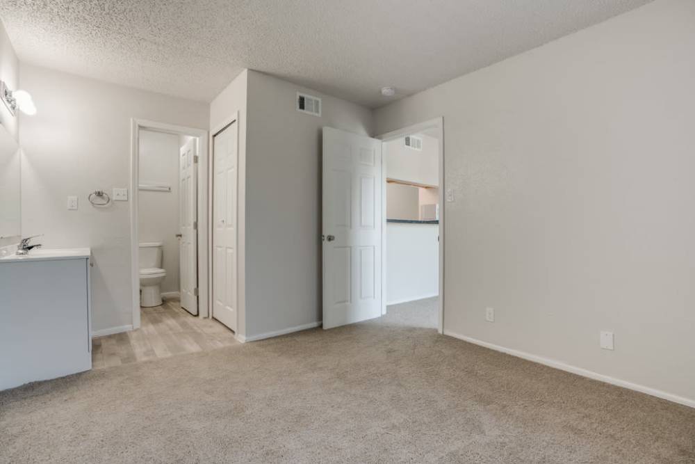 Unfurnished master bedroom with access to bathroom at Woodland Apartments San Antonio in San Antonio, Texas