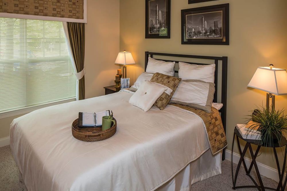 Primary bedroom with classic furnishings in a model apartment at The Preserve at Greison Trail in Newnan, Georgia