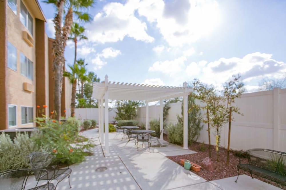 Exterior on a sunny day with foliage and seating at Sherwood Village Assisted Living & Memory Care in Tucson, Arizona