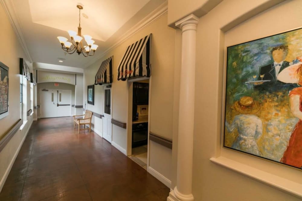 Brightly lit hallway with painting at RockBrook Memory Care in Lewisville, Texas
