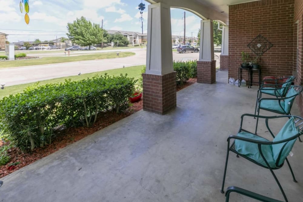 Outside sitting area complete with seating and foliage at Meadow Creek Senior Living in Lancaster, Texas