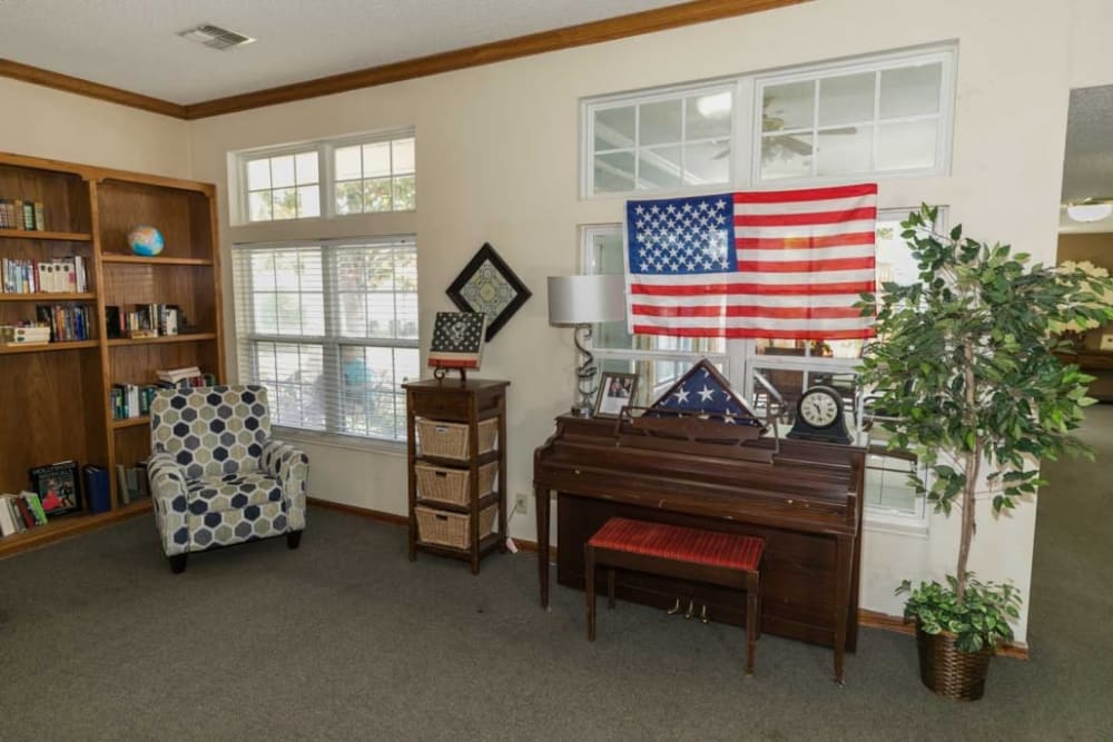 Seating area complete with piano and American flag at Cedar Hill Senior Living in Cedar Hill, Texas
