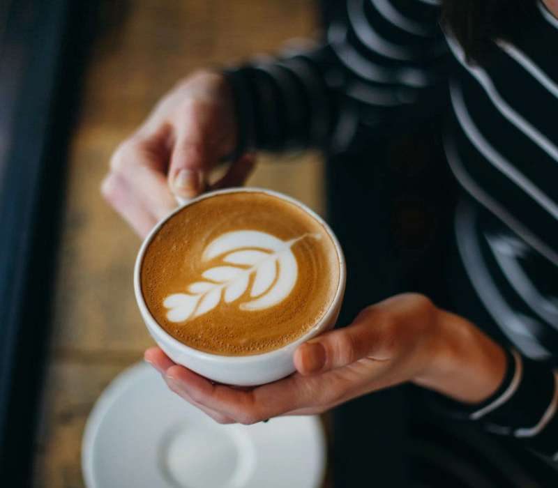 Resident holding a cup of coffee at The Beacon in Fremont, California
