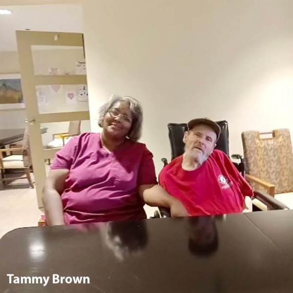 Caregiver Tammy sitting at a table with a male resident