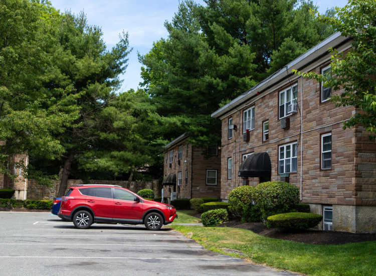 Red car parked in front of apartment building at Westfield Condominium in Brockton, Massachusetts