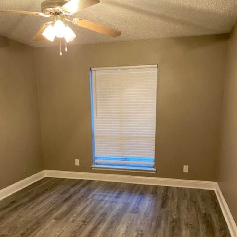 Spacious bedroom with windows and ceiling fan at Mission Pointe Club Apartments in Euless, Texas
