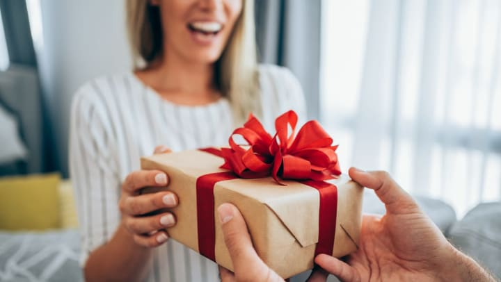 woman smiling as someone gives her a gift | gift shops in Katy