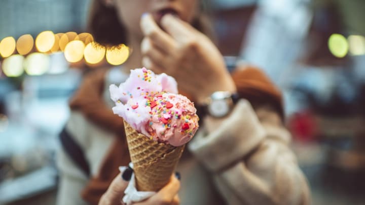 close-up of a pink ice cream cone with rainbow sprinkles | local sweet stores